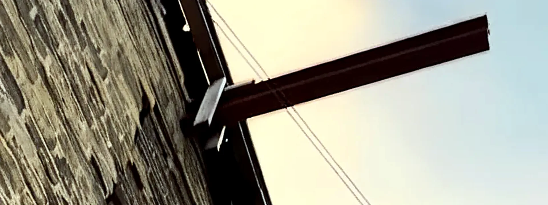 Steel beams cantilevering from the wall of a stone building